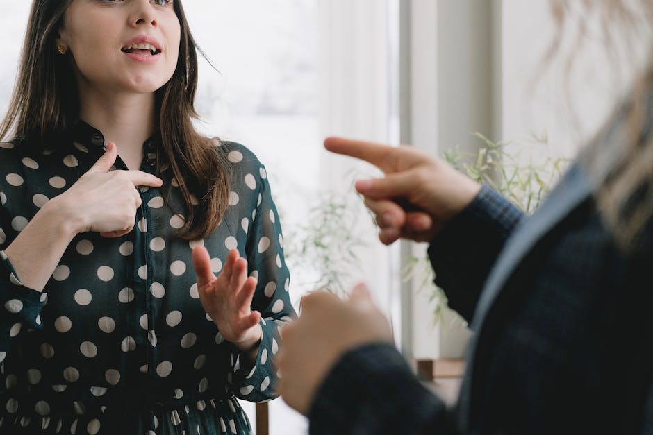 A person holding a document while talking to someone, representing a dispute over security deposit deductions.