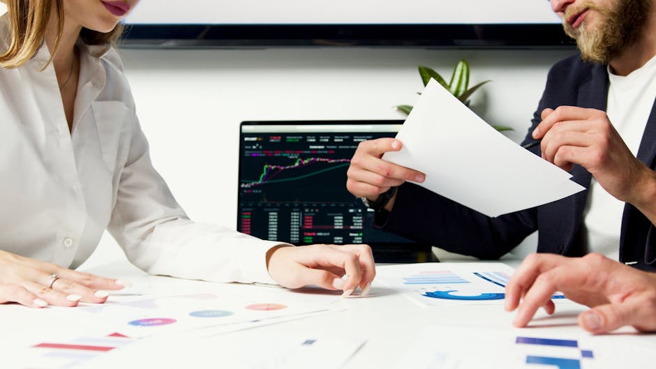 An image showing a landlord and a tenant discussing paperwork in an office setting, symbolizing cooperation and financial assistance for landlords