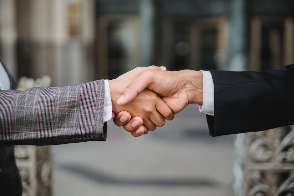 An image describing the understanding of lease agreements, with two people shaking hands in front of a house.