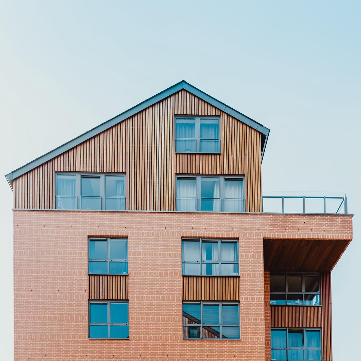 Image illustrating the importance of renters insurance for landlords, showing a landlord holding a safety net over a rental property.